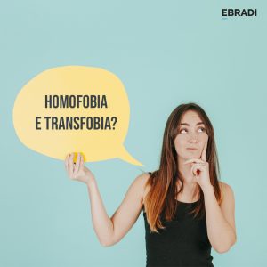 mulher segurando um cartaz com os dizeres homofobia e transfobia